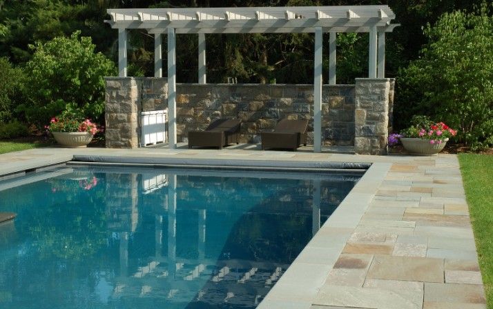 Piscina de obra con coronación de piedra Piscina de obra terminada con coronación de piedra natural y pérgola de madera