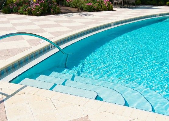 Piscina terminada con escalera de obra, cascada y coronación de piedra clara