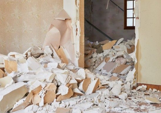 Derribo de tabiquería en vivienda Vivienda en vaciado con el escombro del tabique derribado amontonado sobre el suelo